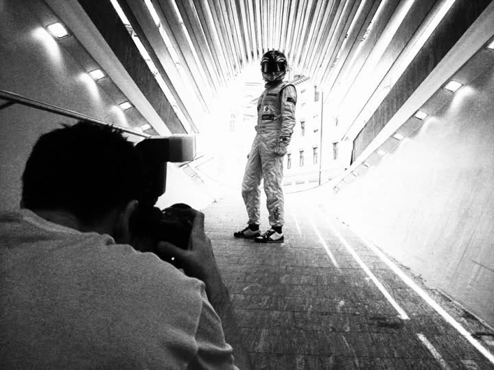 Black-and-white behind-the-scenes photograph with converging architectural lines