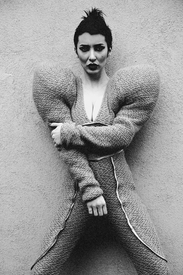 Black-and-white fashion portrait with sculptural knit shoulders