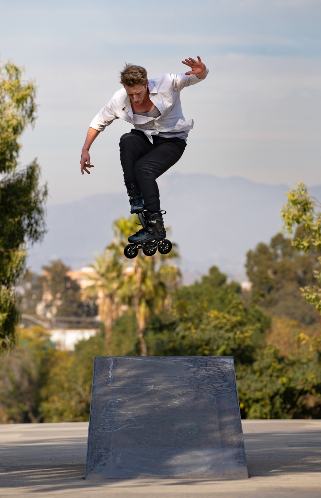 Inline skater jumping above a ramp by Jeff Linett