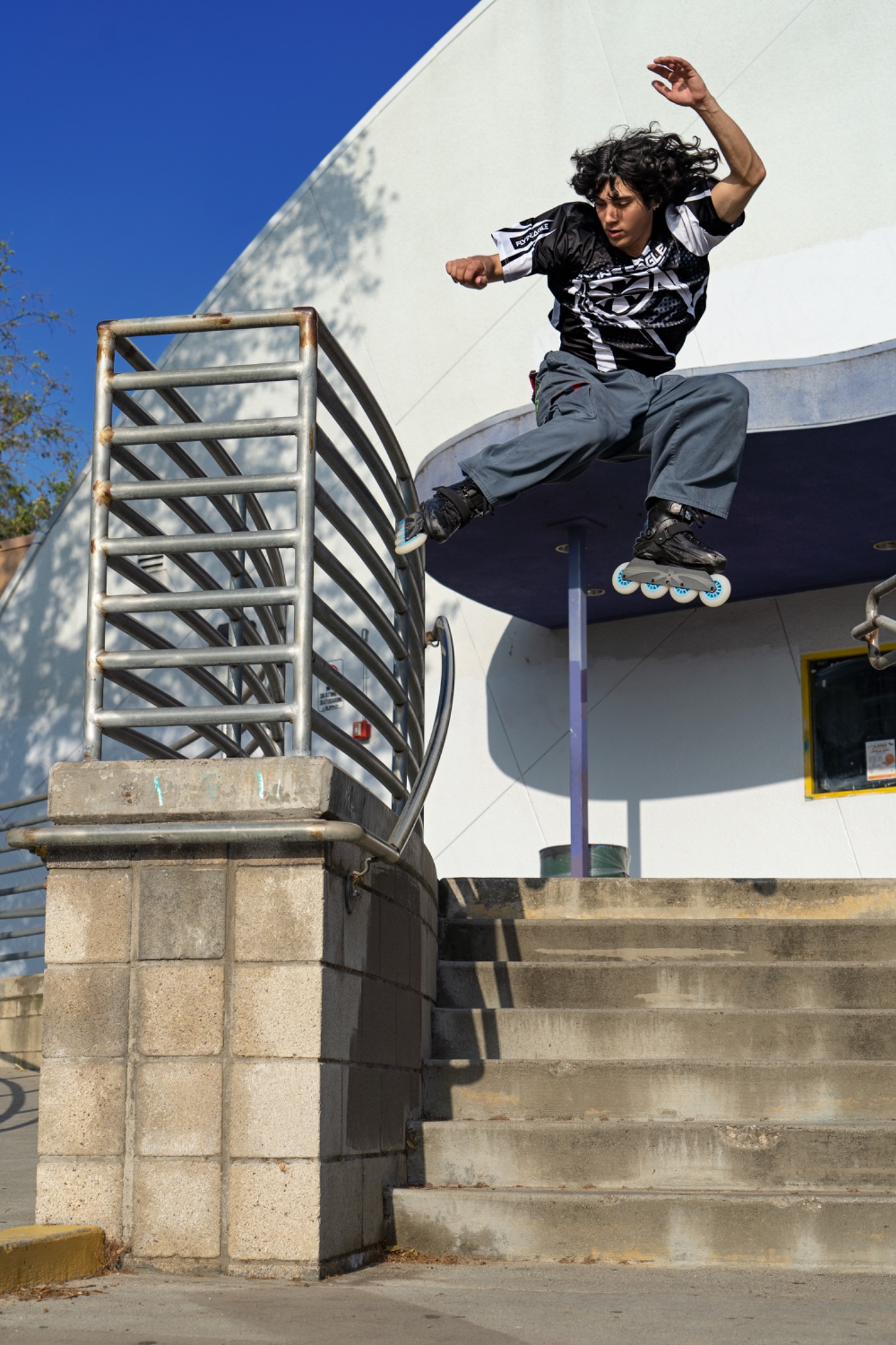 Inline skater jumping beside stairs by Jeff Linett